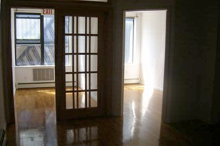 This “cozy" two-bedroom in NYC’s Lower East Side can be yours for a monthly rental price of $3,200. It even comes with its own "exit" sign. Image via Craigslist